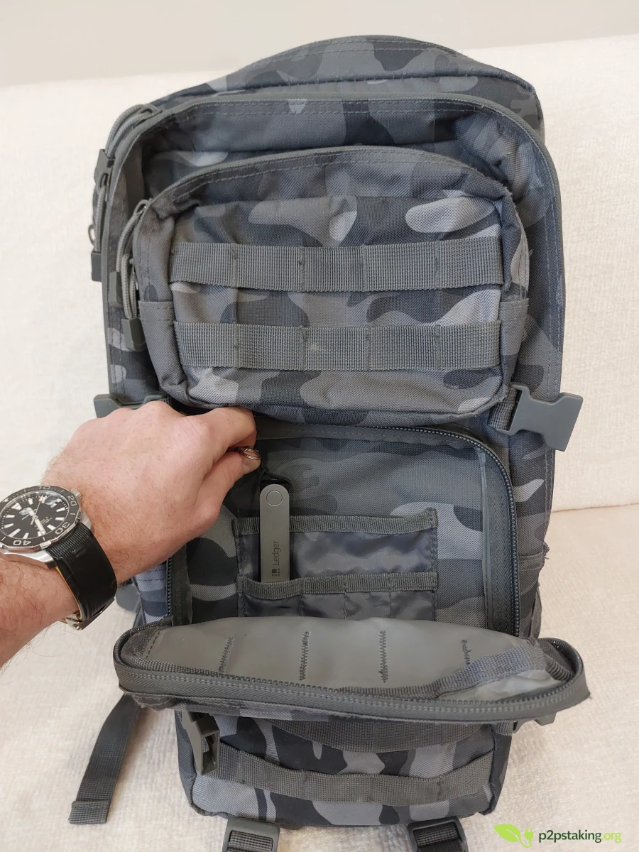 putting a ledger nano x in front poker of a bag